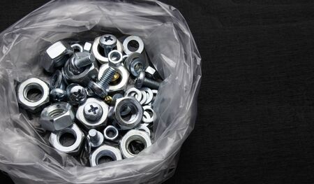 bolts, nuts and other on black background. Top viewの写真素材