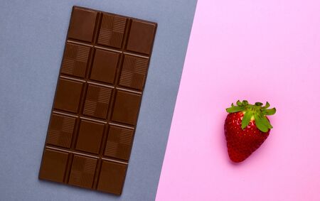 Juicy strawberries. Bar of chocolate. Colored backgrounds