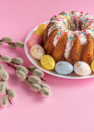 Easter holiday table with first flowers, decorations and traditional ring cake in pastel color compositionの写真素材