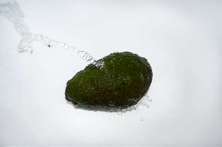 Avocado with a water jetの写真素材