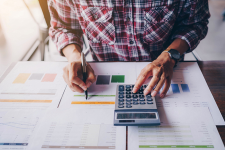 Close up of businessman working on calculator to calculate business data the financial report. Business financial analysis and strategy concept.の写真素材