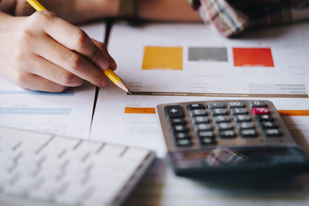 Businesswoman analyzing investment charts with calculator for financial data analyzing counting. Business financial analysis and strategy concept.の写真素材
