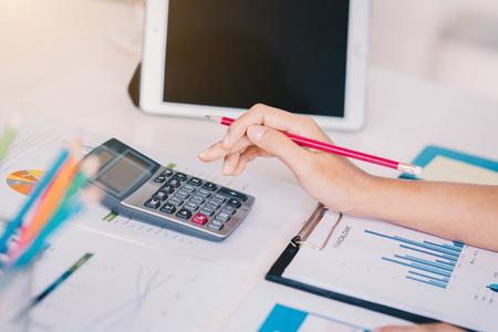 Business woman working with new startup project discussion and analysis data financial report. Using a calculator to calculate numbers.Business financial and accounting conceptの写真素材