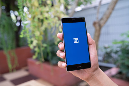 CHIANG MAI, THAILAND - August 05,2018: Man hands holding HUAWEI mobile phone with Linkedin application on the screen. Linkedin is a business and employment oriented social networking service.のeditorial素材