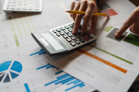 Businesswoman hands holding pen working  with calculator to calculate the numbers.Business finances and accounting concept.の写真素材