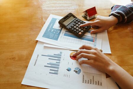 Woman press the calculator to calculating financial chart for investment to buying propertyの写真素材