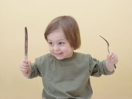 little boy with fork and knife ready to eatの写真素材