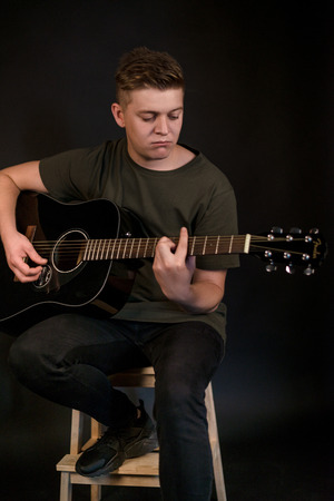 Guy in studio play on acoustic guitar
