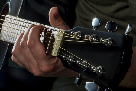 hands play on acoustic guitar