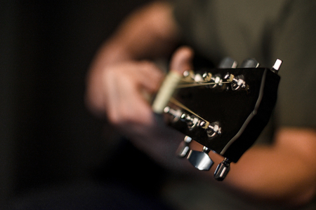hands play on acoustic guitar