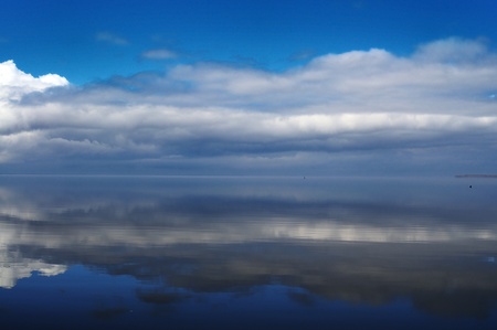 Dark blue water with reflection of cloudsの写真素材