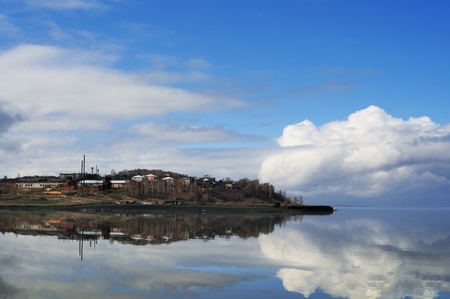 Coastal settlement and the big cloud reflected in waterの写真素材