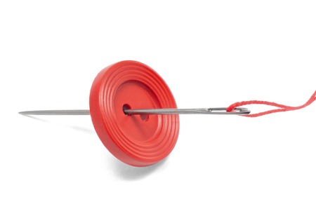 Red thread, button and needle isolated on whiteの写真素材