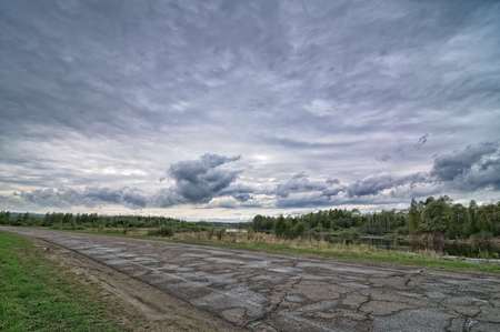 Old country asphalt road, storm dark skyの写真素材
