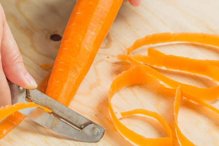 Someone is peeling the carrot for cook.の写真素材