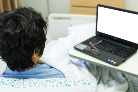 Female patient is watching computer screen for chat with children or read some newsの写真素材