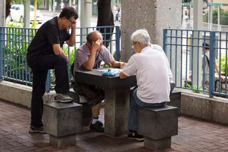 Hong Kong - October 22, 2016 : Group of old men in Hong Kong are playing chess under building in their free timeのeditorial素材