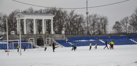 Kirovsk, Russia, March 17, 2019. Children play football in the stadium on the snow.のeditorial素材