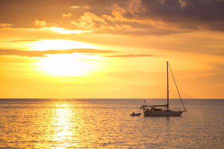 Sailboat on the ocean at sunsetの写真素材