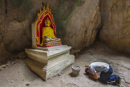 a man doing respect Buddha state in cave Thailandのeditorial素材
