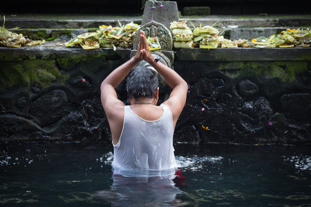 Man in Holy Spring Water Tirta Empul Hindu Temple , Bali Indonesiaの写真素材