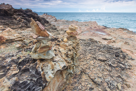 Pebbles and stones stacked on a rock seashoreの写真素材