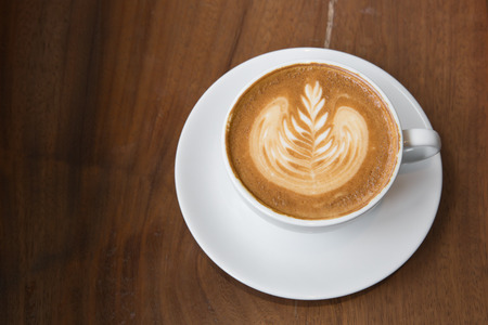 Coffee latte art on wood tableの写真素材