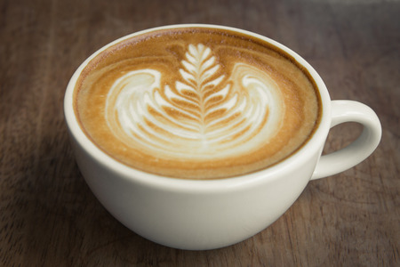 Coffee latte art on wood tableの写真素材