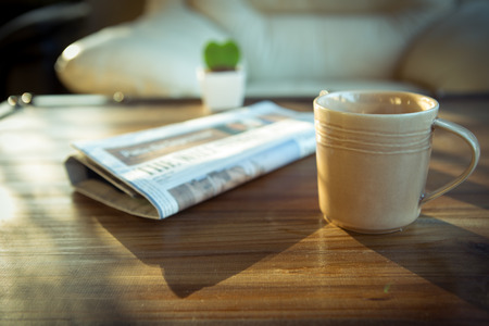 a cup of coffee with newspaper on table at coffee shopの写真素材