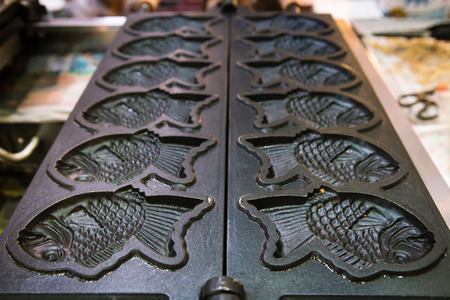 Waffle machine making , fish moldの写真素材