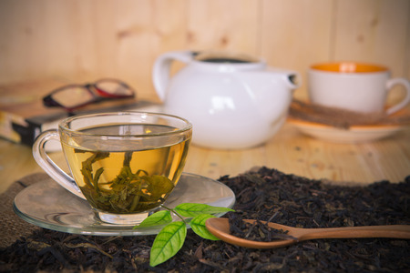 tea in the cup with dry tea and tea mix background  on tableの写真素材