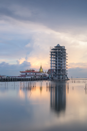 Beautiful sunset twilight at Hong Thong Temple in Thailand , unseen the chapel and pagoda in the seaの写真素材