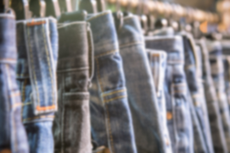 Blurred of  row of hanged blue jeans in a shopの写真素材