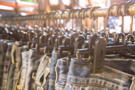 Blurred of row of hanged blue jeans in a shopの写真素材