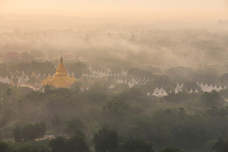 Golden pagoda of Mandalay at morning with warm sunlight and fog , landmark of Mandalayの写真素材