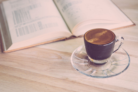 Cup of coffee with books on wood tableの写真素材