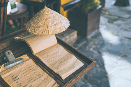 Tradition of Vietnamese hat decoration above coffee and beverage menu in front of cafe Vietnamの写真素材