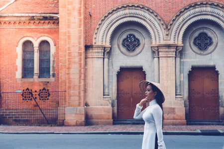 HOCHIMINH CITY, VIETNAM, NOVEMBER 04 : unidentified Vietnamese girls wearing white Ao dai on the street on November 04, 2016. Ao dai is famous traditional Custume for women in Vietnam.のeditorial素材