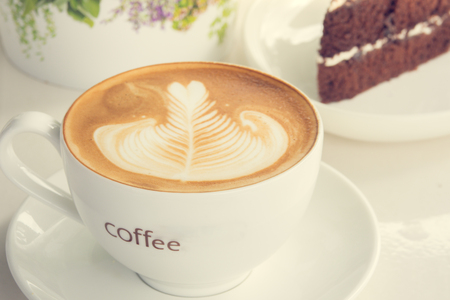 A cup of cofee  latte art on white table in cafeの写真素材