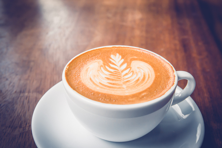 Coffee latte art on wood tableの写真素材