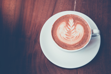 Coffee latte art on wood tableの写真素材