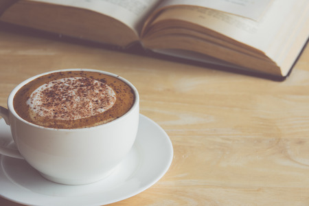 cup of latte or cappuccino coffee with a book in coffee shopの写真素材