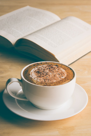 Cup of coffee with book in coffee shop vintage colorの写真素材