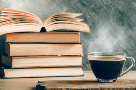 Black coffee on wood plate with stack old booksの写真素材