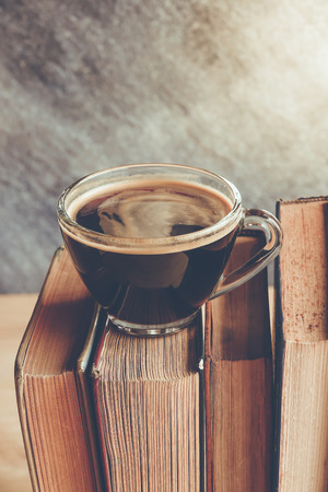 Black coffee on row of books , retro color toneの写真素材