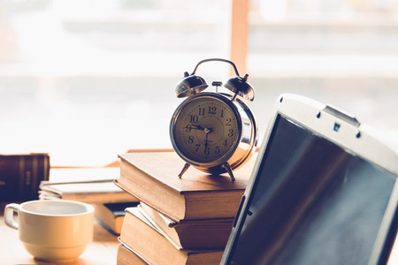 Alarm clock on stack books on top of office table