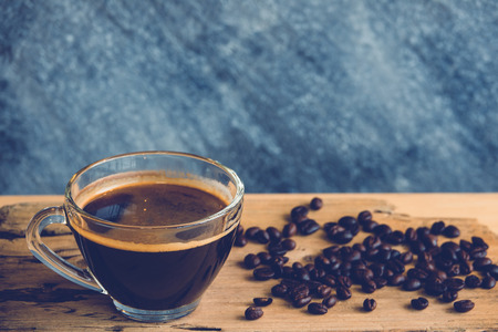 Coffee cup with coffee bean on brown wooden tableの写真素材