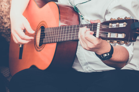 Selective focus hand of little boy is playing the guitarの写真素材