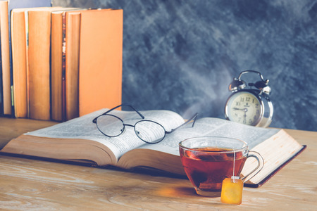 Cup of tea and book with classic glasses , retro color toneの写真素材