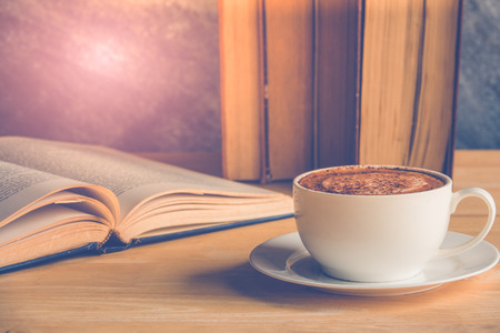 Cup of coffee cappuccino with old books on tabelの写真素材
